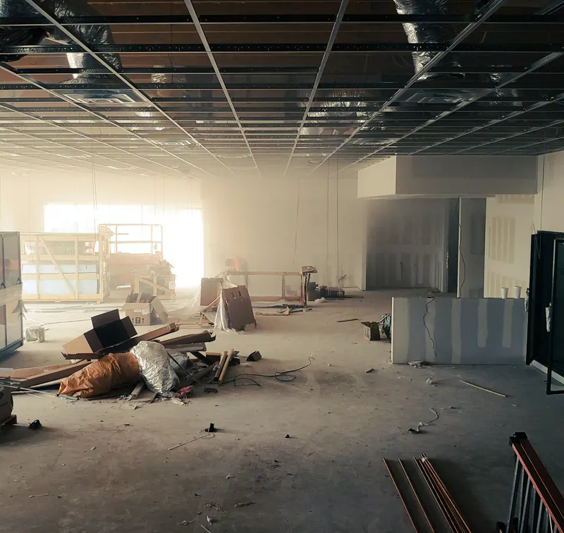Commercial space stripped to the shell during a build-out, with debris on the floor