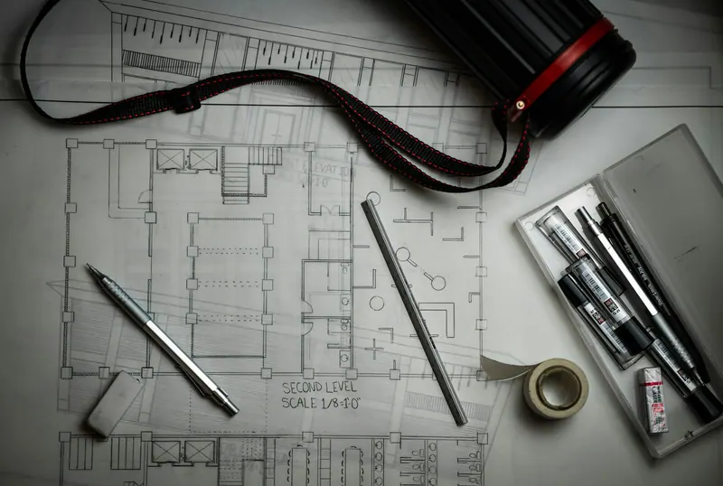 Building plans with drafting pencils, a ruler and a drawing tube
