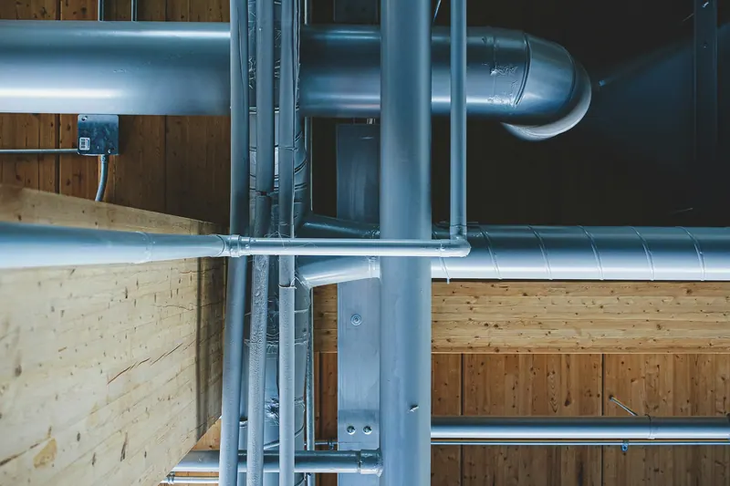 New pipes run through the framing between floors